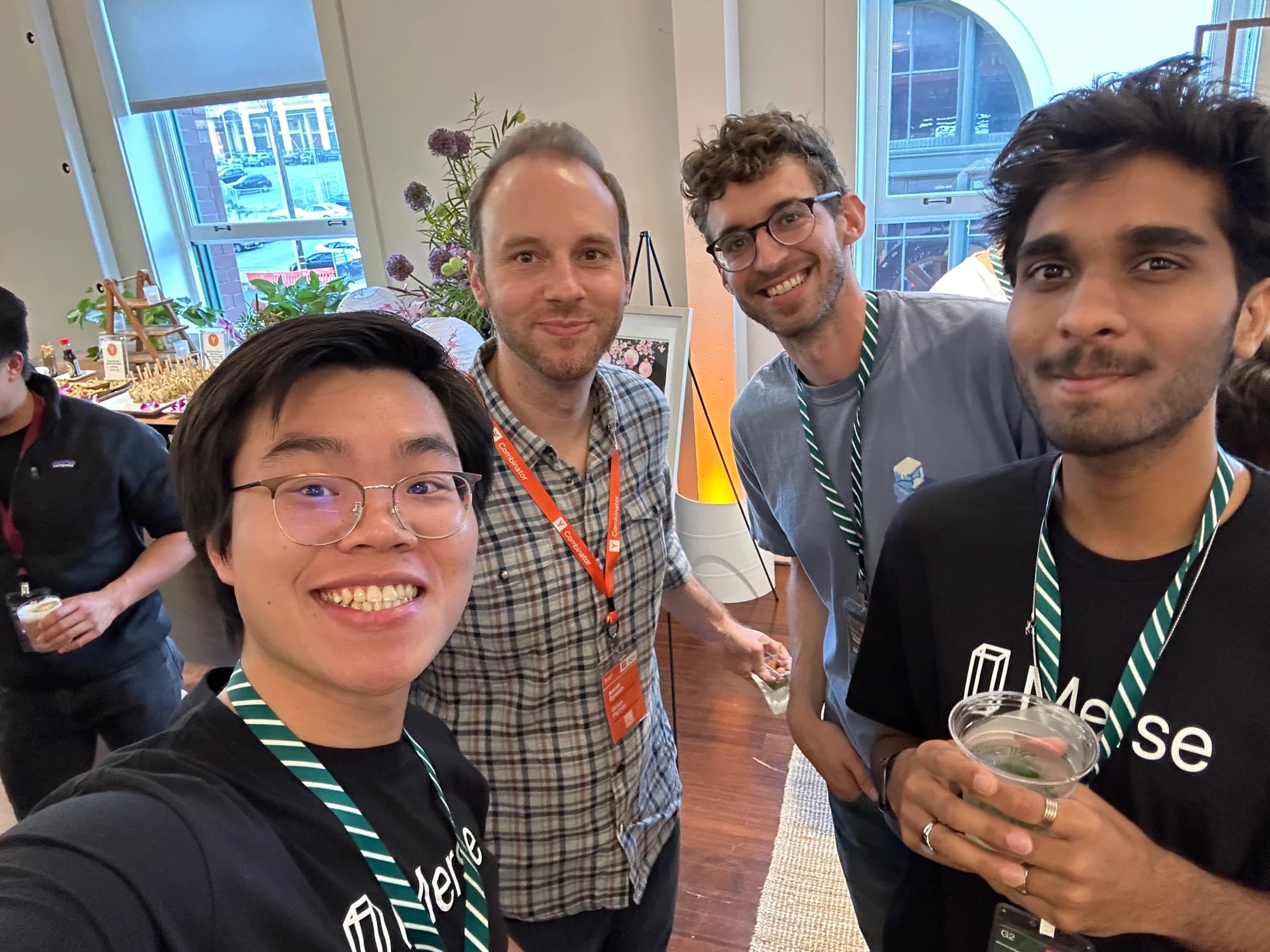 A group selfie at a YC gathering, with two people wearing Merse T-shirts.
